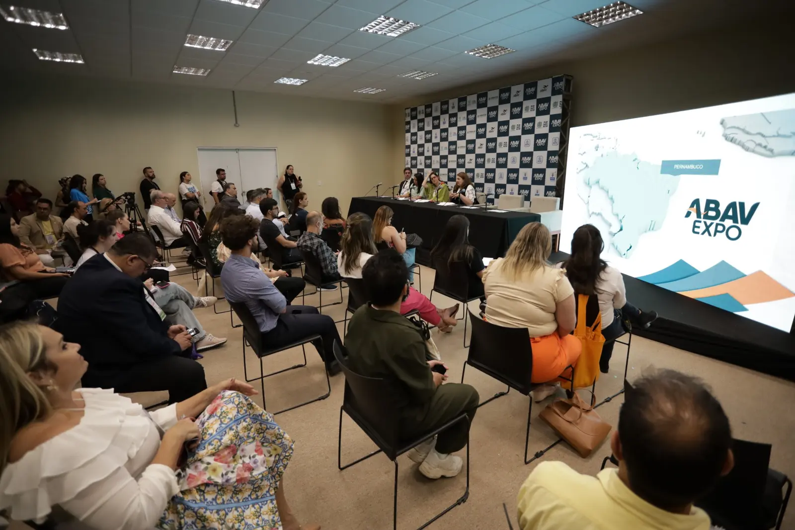 Coletiva da ABAV Expo 2022 com telão e mapa do Brasil destacando Pernambuco