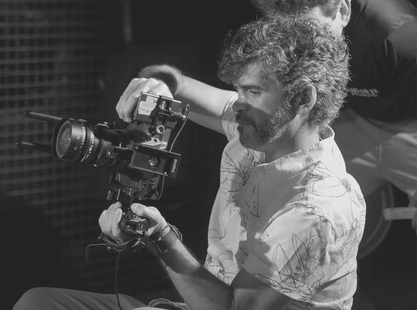 Diretor de fotografia com câmera de cinema na mão, em foto preto e branco de bastidores