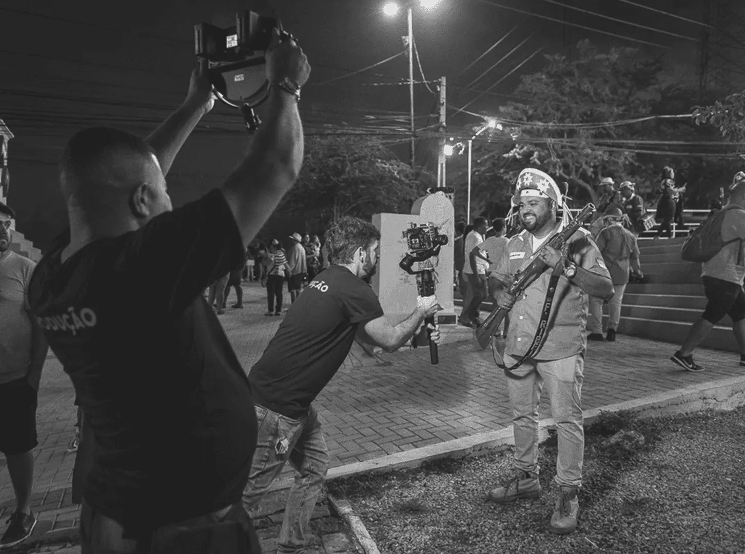 Equipe da Cacoete filmando festa popular à noite com estabilizador