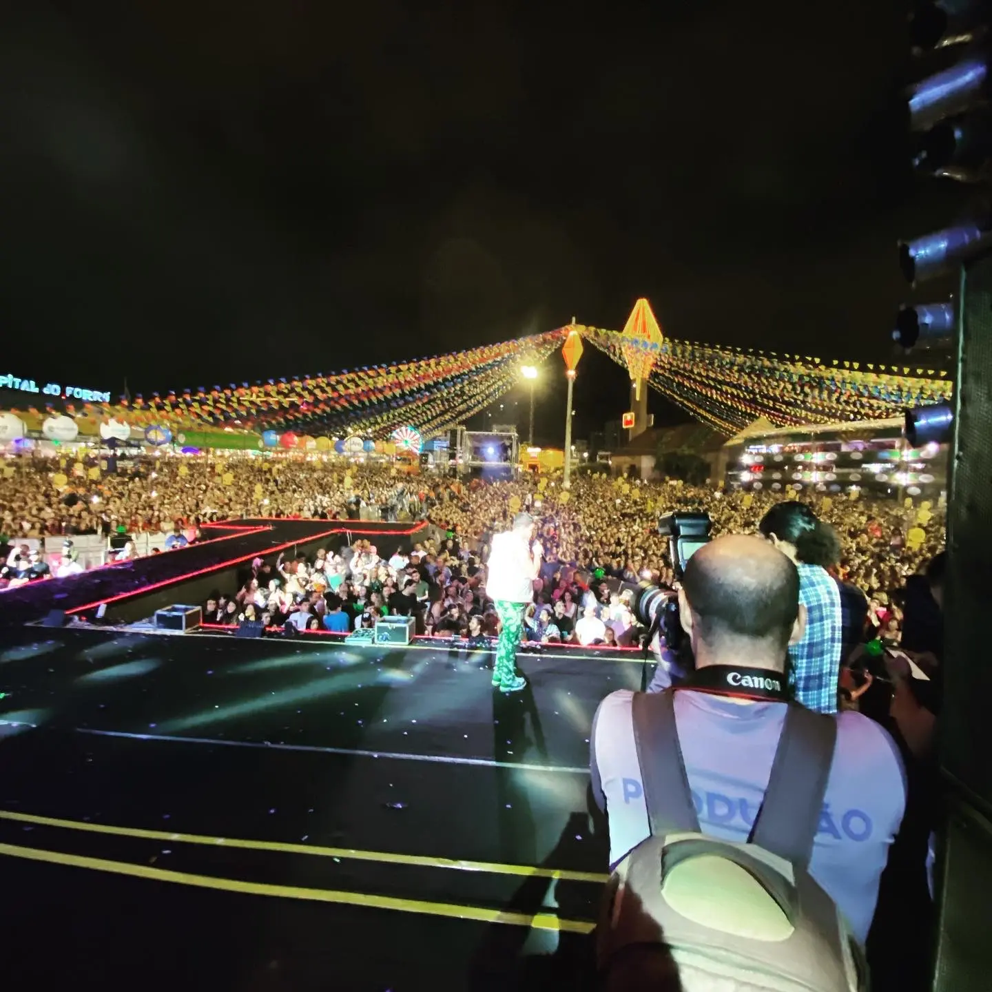 Fotógrafo da Cacoete em cima do palco do São João de Caruaru, de frente para a multidão