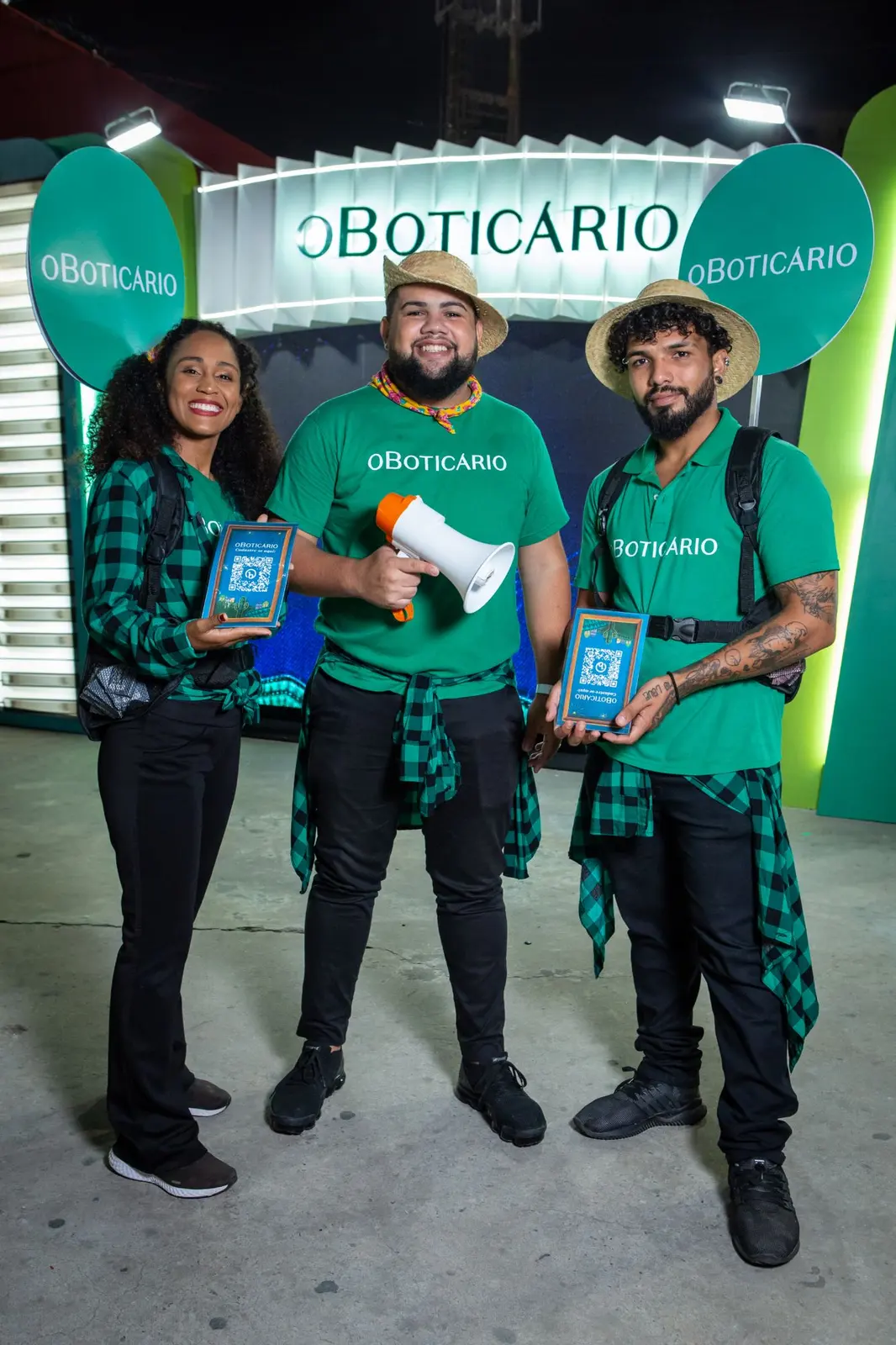 Promotores de O Boticário com trajes de São João e cartões com QR code